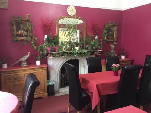 a dining room with a table and a fireplace at St. James's Guest House in London