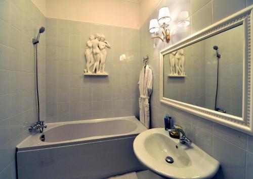 La salle de bains est pourvue d'une baignoire, d'un lavabo et d'un miroir. dans l'établissement Queen Valery Hotel, à Odessa