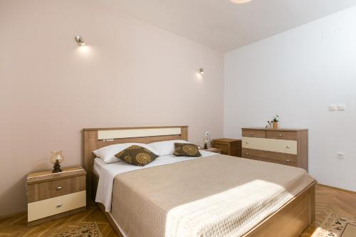 um quarto com uma cama com duas mesas de cabeceira e uma cama sidx sidx sidx em Apartments Oliva em Cavtat