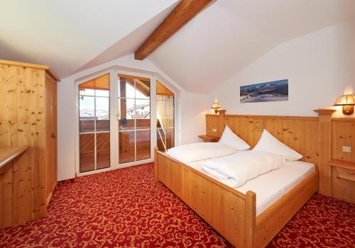 a bedroom with a bed and a large window at Aparthotel Paradies in Flachau