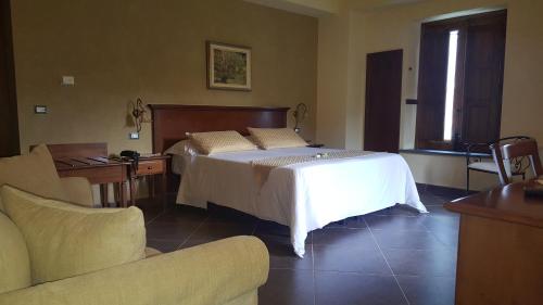 a bedroom with a bed and a couch at Antico Borgo Petralia in Zafferana Etnea