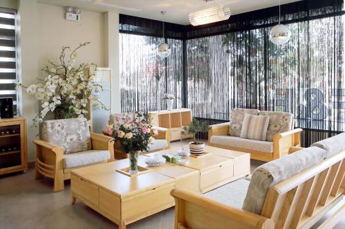 a living room with couches and a table with flowers at F & F Hotel in Hai Phong