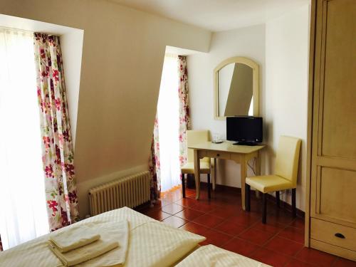um quarto com uma cama, uma secretária e um espelho em Hotel Ratskeller em Zell an der Mosel