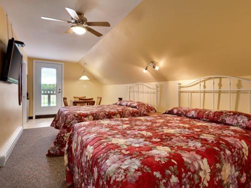 a bedroom with two beds and a ceiling fan at Travelodge by Wyndham Fredericton in Fredericton