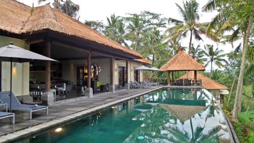 a resort with a swimming pool and a restaurant at Rouge - Private Villa Condense in Ubud