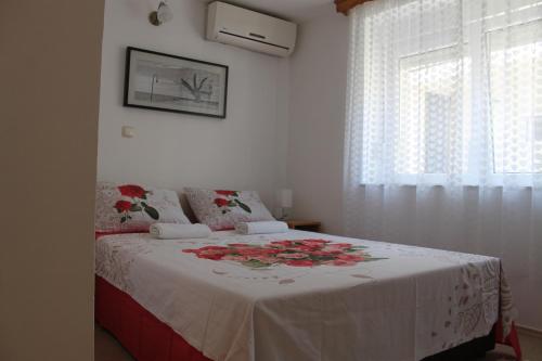 a bedroom with a bed with a white blanket and a window at Hostel Lena-Mostar in Mostar
