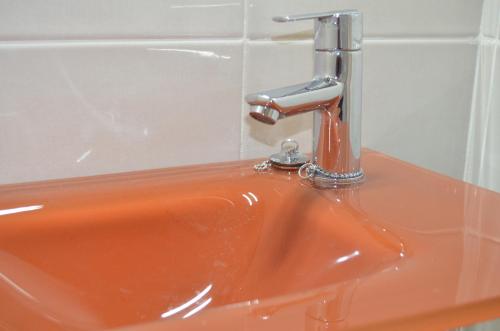 an orange sink with a faucet on top of it at ApartSuits Tarragona Rambla Nova 24 in Tarragona