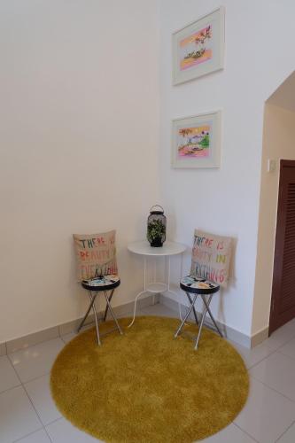 a white room with two chairs and a table at Home Sweet Home in Semenyih