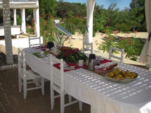 einen weißen Tisch mit einer Schale Obst drauf. in der Unterkunft Le Jardin de L'isle in Ifaty
