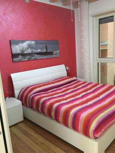a bedroom with a bed with a red wall at Savonaamare in Savona