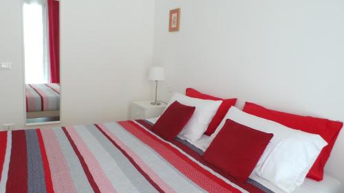 a bedroom with a bed with red and white pillows at Zenzero e Limone in Siracusa