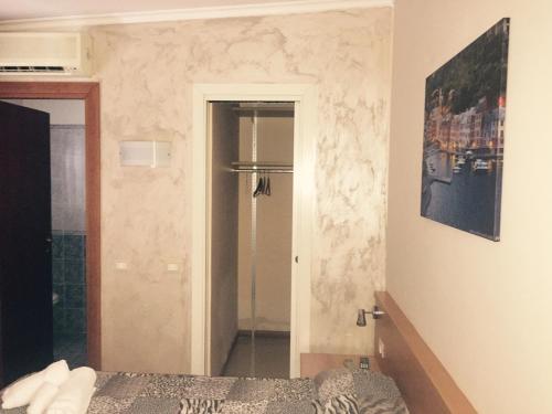 a bedroom with a bed and a refrigerator in it at Hotel Villa Flora in Bogliasco