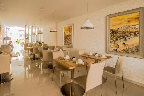 a restaurant with tables and chairs and a painting on the wall at Sea Garden Peniche in Peniche