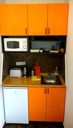 a kitchen with orange cabinets and a sink at Penzion V Roklich & Apartmens V Roklich in Ricany