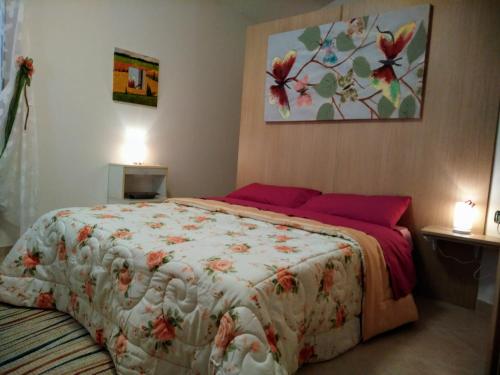Appartamento Berlicche في Agliana: غرفة نوم بسرير كبير مع بطانية مزهرة