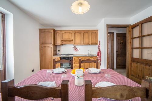 a kitchen with a table with a pink table cloth at Seconda stella a destra in Valgrisenche