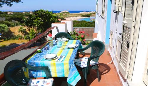 a table on a balcony with a view of the ocean at Capo Testa Vista Mare in Santa Teresa Gallura