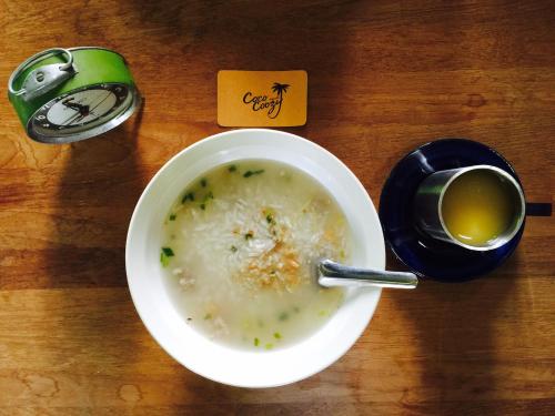 a bowl of soup and a cup of tea on a table at Coco Coozy in Kanchanaburi