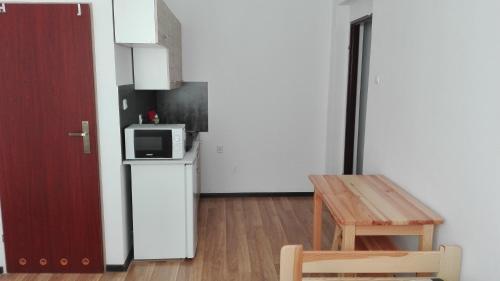 a kitchen with a wooden floor and wooden cabinets at Hostel Sosnowiec in Sosnowiec