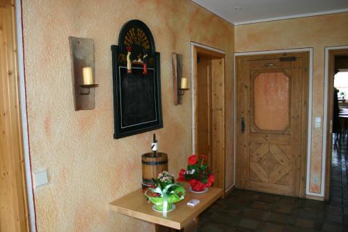 a hallway with a door and a table with flowers at Gasthaus Mösle in Reute
