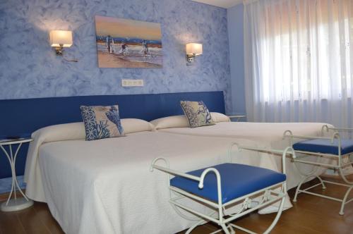 a bedroom with two beds and blue walls at Hotel el Pinar in Villapedre