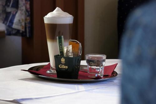 a cup of coffee and a glass of water on a table at Hotel Gabreta in Sušice