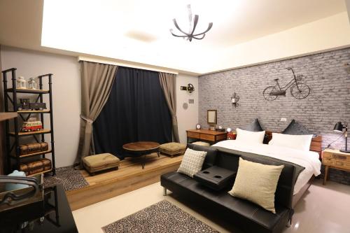 a bedroom with a large bed and a couch at Aria 2 Home (With Elevator) in Hualien City