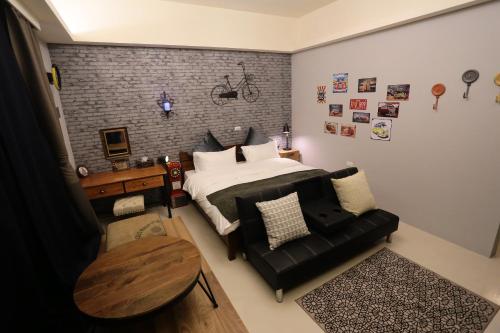 a bedroom with a bed and a black leather couch at Aria 2 Home (With Elevator) in Hualien City