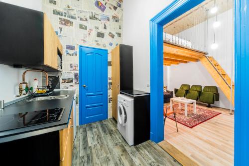 ブダペストにあるKazinczy At Szimpla Apartmentの青いドア、洗濯機、乾燥機付きのキッチンが備わります。