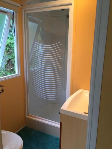 une salle de bain avec douche et lavabo dans l'établissement Camping les Orangers, à San-Martino-di-Lota