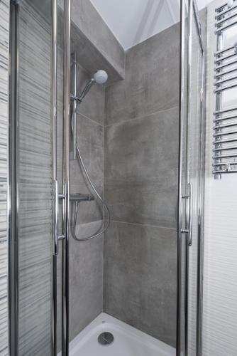 une douche avec une porte vitrée dans une salle de bain dans l'établissement At home in lyon, à Lyon
