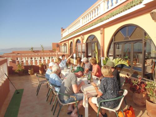 een groep mensen die aan een tafel op een patio zitten bij Villa Sunset B&B in Aourir