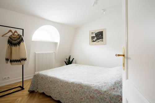 um quarto branco com uma cama e uma janela em Vana-Posti Apartment em Talin