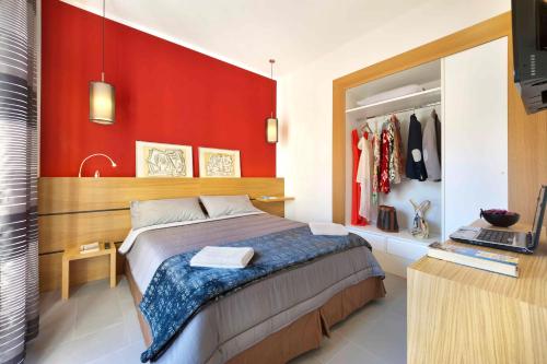 ソレントにあるOrsola Sorrento sea & sunの赤い壁のベッドルーム1室(ベッド1台付)