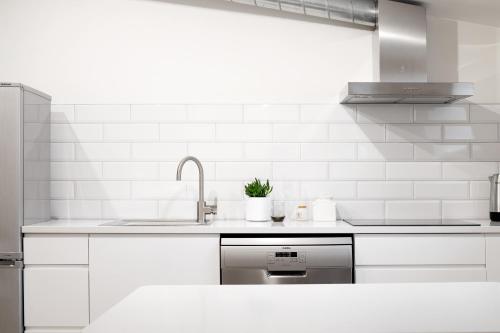 cocina blanca con fregadero y encimera en Vana-Posti Apartment, en Tallin