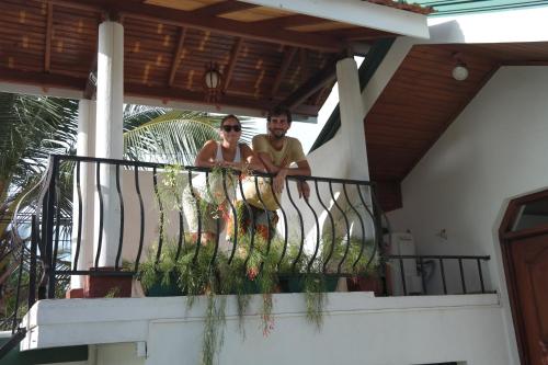 a man and a woman standing on a balcony at Romeo and Juliet Guest House in Negombo