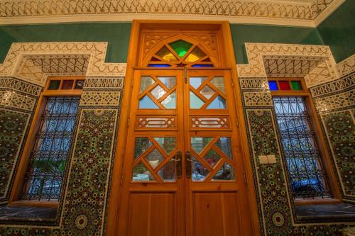 a pair of wooden doors with stained glass at Riad Scalia Traditional Guesthouse Fes Morocco in Fès