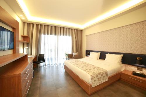 a hotel room with a bed and a television at Urban Central Suites - Beirut in Beirut