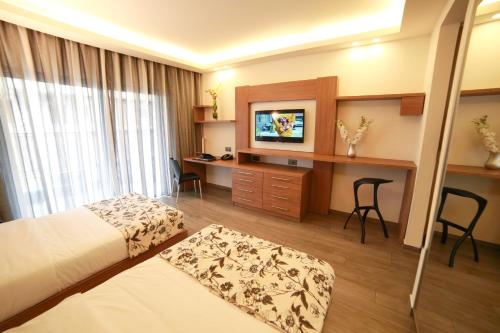 um quarto de hotel com uma cama e uma secretária em Urban Central Suites - Beirut em Beirute