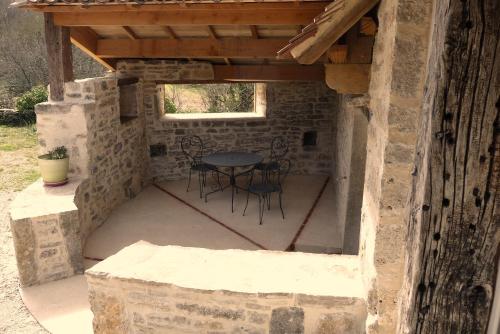 a patio with a table and chairs in a stone building at La Hulotte in Limogne-en-Quercy