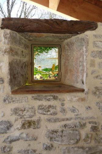a window in a stone wall in a room at La Hulotte in Limogne-en-Quercy