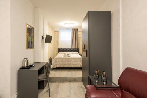 ein Hotelzimmer mit einem Bett, einem Schreibtisch und einem Zimmer in der Unterkunft Rifugio degli Artisti Top B&B in Rom