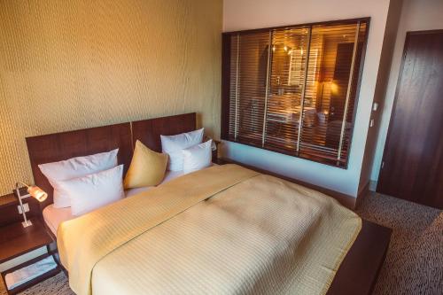 a bedroom with a large bed and a window at Lindenhof Hotel Tepe in Damme