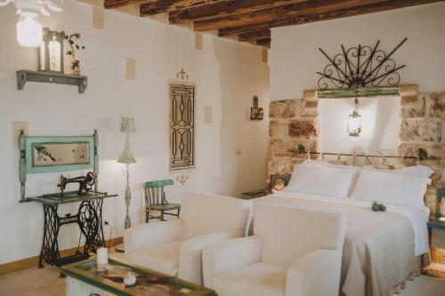 a bedroom with a bed and a couch and chairs at Masseria Montenapoleone in Fasano