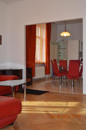 a living room with red chairs and a table at Apartment Riverside - River View in Bratislava
