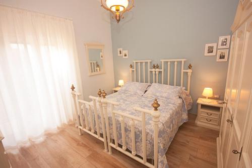 ein Schlafzimmer mit einem weißen Bett und einem Fenster in der Unterkunft Il Punto a Maglie in Maglie