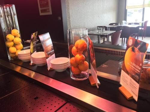 Un buffet con naranjas y platos en una mesa. en Campanile Nantes ~ Saint-Herblain, en Saint-Herblain