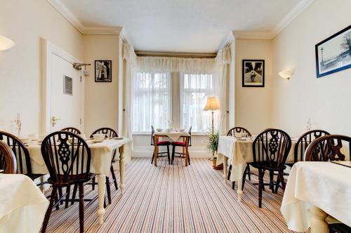 a dining room with tables and chairs and a window at Dolphin Guesthouse in Scarborough