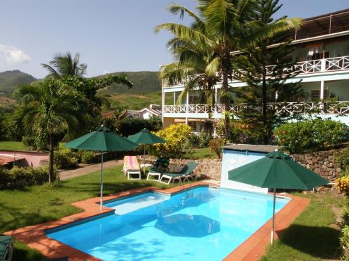 una piscina con sombrillas frente a un hotel en Tamarind Tree Hotel, en Salisbury
