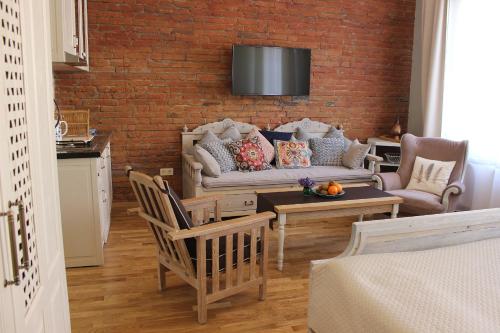 a living room with a couch and a brick wall at Leather Lane in Tbilisi City